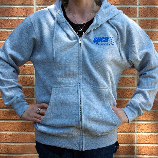 Woman wearing grey sweatshirt with blue spcaLA logo over left chest area