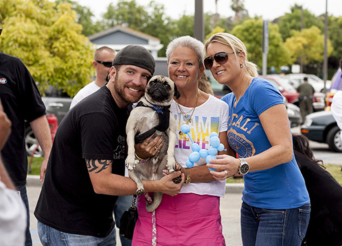 djs heidi and frank with adopter holding a pug